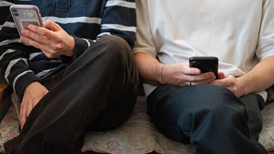 Zwei Männer halten ihre Smartphones in den Händen
