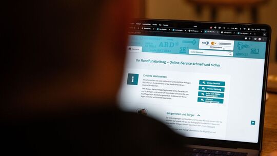 Person schaut auf die Webseite des Beitragsservice