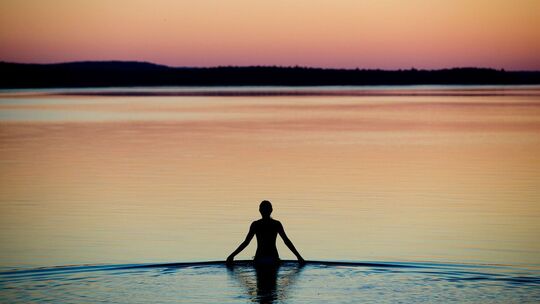 Frau badet an einem Sommerabend im Brombachsee