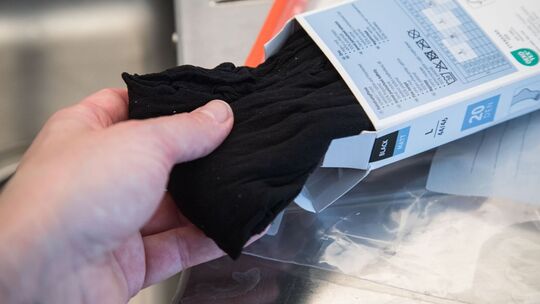 Frau nimmt eine Strumpfhose aus der Verpackung