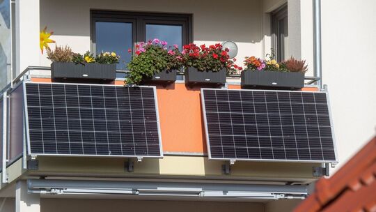 Solarmodule für ein Balkonkraftwerk hängen an einem Balkon