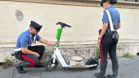 Tourist mit antikem Marmorsockel auf einem E-Scooter