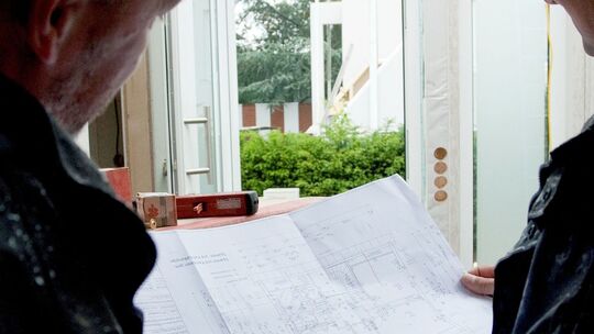 Bauleiter und Monteur besprechen Bauplan