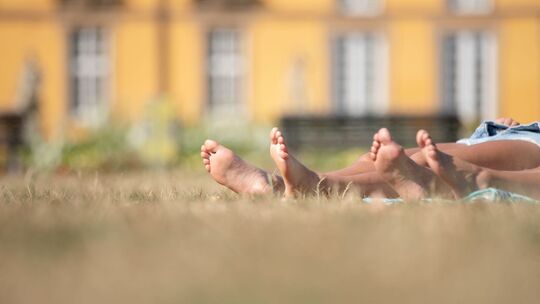 Die nackten Füße zweier Frauen in einem Park