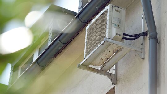 Klimaanlage an der Hauswand eines Mehrfamilienhauses