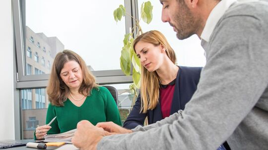 Drei Personen in einem Meeting