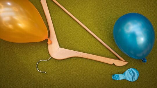 Luftballons liegen neben einem Kleiderbügel