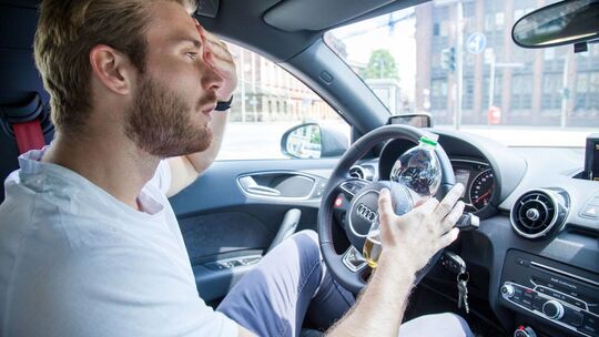 Mann fährt bei Hitze Auto