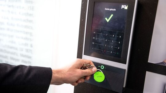 Ein Mitarbeiter erfasst seine Arbeitszeit an einem Terminal