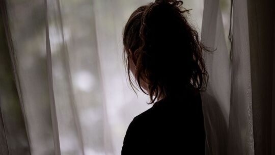 Eine Frau steht am Fenster
