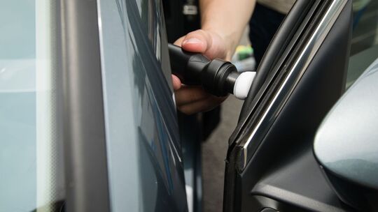 Ein Mann pflegt die Gummidichtung einer Autotür