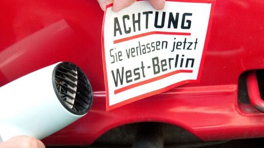 Ein Mann entfernt einen Aufkleber vom Auto