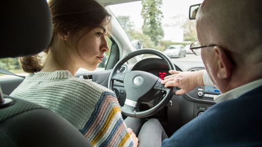 Eine Fahrschülerin mit ihrem Fahrlehrer