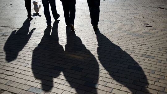 Schattenumrisse einer Gruppe auf Kopfsteinpflaster