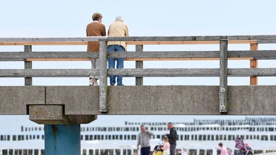 Spaziergänger stehen auf der Seebrücke Graal-Müritz
