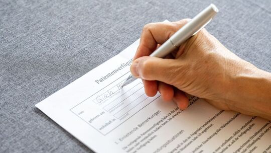 Eine Person füllt eine Patientenverfügung aus