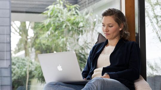 Junge Frau arbeitet am Laptop.