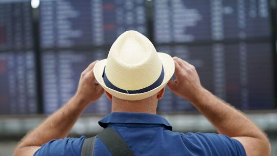 Ein Flugreisender steht vor den Check-In-Schaltern