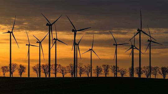 Windräder in einem Windpark bei Sonnenaufgang