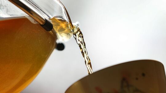 Grüner Tee wird in eine Tasse gegossen