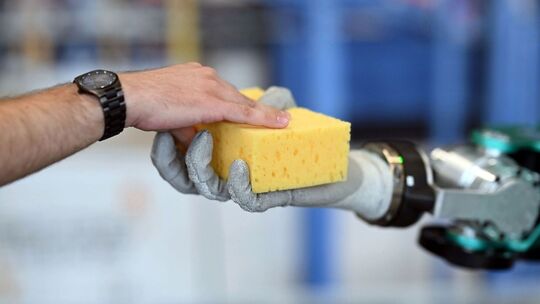 Ein Humanoider Roboter ARMAR-6 hält einen Schwamm in der Hand