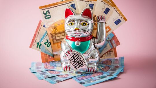 Japanische Glückskatze Maneki-neko mit Geldscheinen