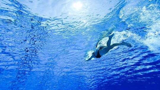 Frau schwimmt im Freibad