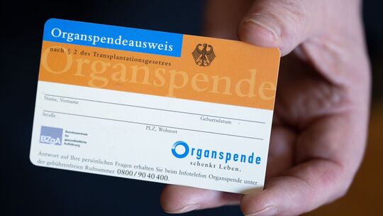 Frau hält einen Organspendeausweis in der Hand