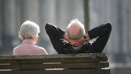 Zwei ältere Menschen sitzen auf einer Bank