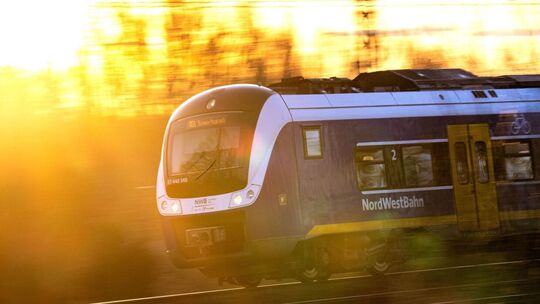 Zug der NordWestBahn im Sonnenaufgang