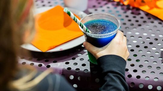 Kind trinkt ein Slush-Eis bei einem Kindergeburtstag