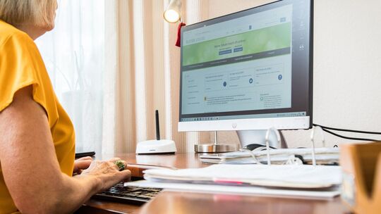 Seniorin macht eine Steuererklärung am PC