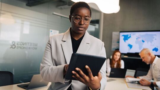 Frau mit Tablet steht in einem Büro