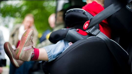 Mädchen sitzt in einem Kindersitz im Auto