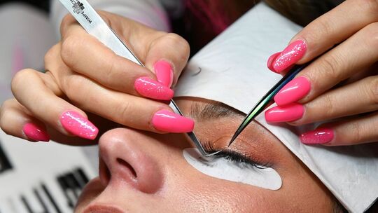 Bei einem Model wird eine Wimpernverlängerung gemacht