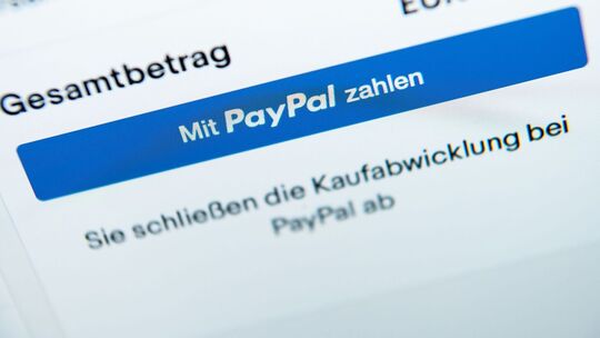 Der Schriftzug «Mit PayPal zahlen» auf einem Laptop