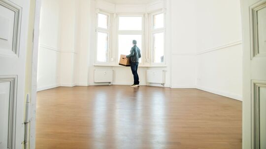 Mann mit Umzugskiste in einer Wohnung