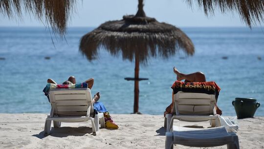 Touristen liegen am Strand in Sousse