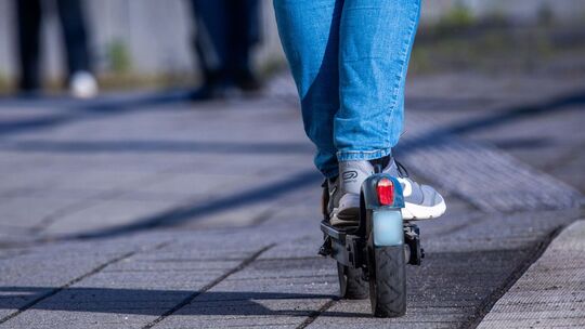 Mann fährt mit einem E-Tretroller