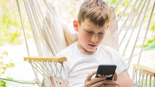 Junge schaut auf sein Smartphone