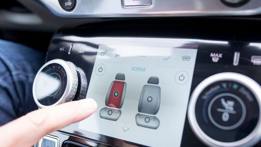 Mann bedient ein Touchdisplay im Auto