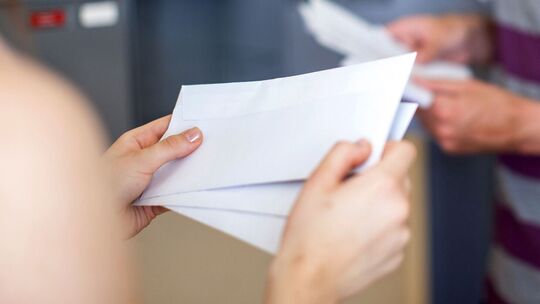 Ein Paar steht am Briefkasten