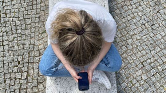 Eine Frau schaut auf ihr Smartphone