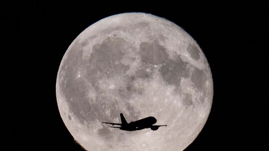 Flugzeug vor dem Vollmond