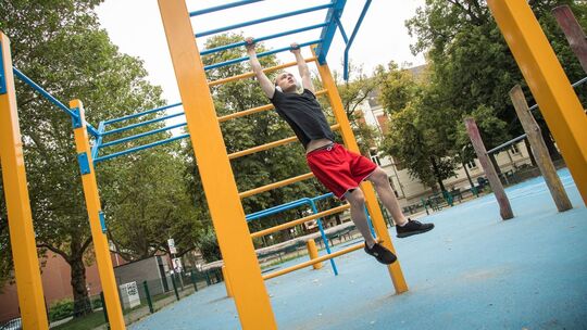 Mann treibt Sport in einem Calisthenics-Park