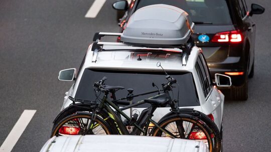 PKW mit Fahrrädern und Dachbox im Stau