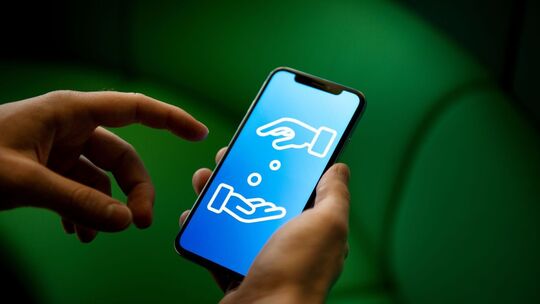 Ein Mann verwende ein Smartphone zum Geldverkehr