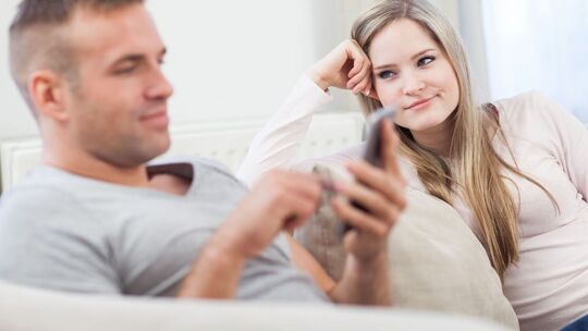 Frau schaut genervt zu ihrem Partner