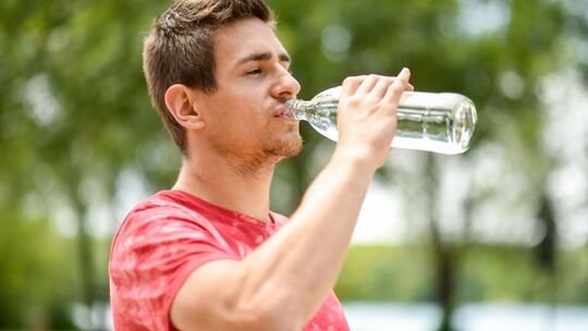 Mann trinkt aus einer Wasserflasche