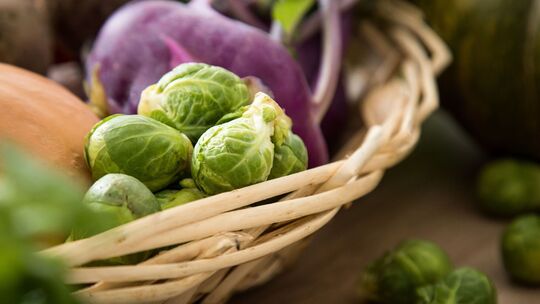 Rosenkohl und violetter Kohlrabi liegen in einem Korb